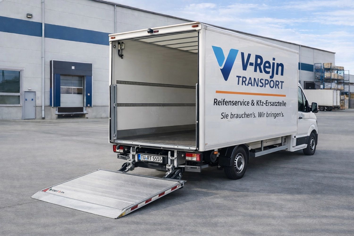 Vr-Transport - Transport · Reifen & KFZ-Ersatzteile - Ein weißer Lieferwagen mit der Aufschrift „VV-Rejn TRANSPORT“ an der Seite parkt vor einem Lagerhaus. Die Ladefläche des Wagens ist offen, und eine Metallrampe führt hinunter zum gepflasterten Boden.