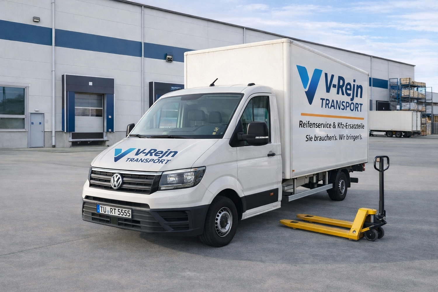 Vr-Transport - Transport · Reifen & KFZ-Ersatzteile - Ein weißer VW-Lieferwagen mit der Aufschrift „V-Rhein Transport“ parkt vor einem Geschäftsgebäude; daneben steht ein gelber Hubwagen. Das Kennzeichen des Lieferwagens ist teilweise erkennbar.