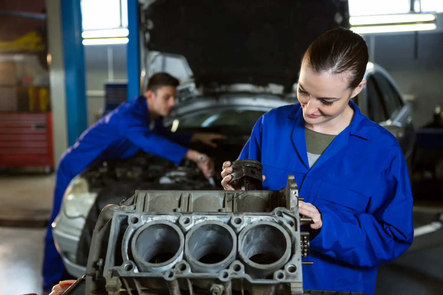 Vr-Transport - Transport · Reifen & KFZ-Ersatzteile - Zwei Mechaniker arbeiten in einer Werkstatt zusammen, um einen Automotorblock zu reparieren.